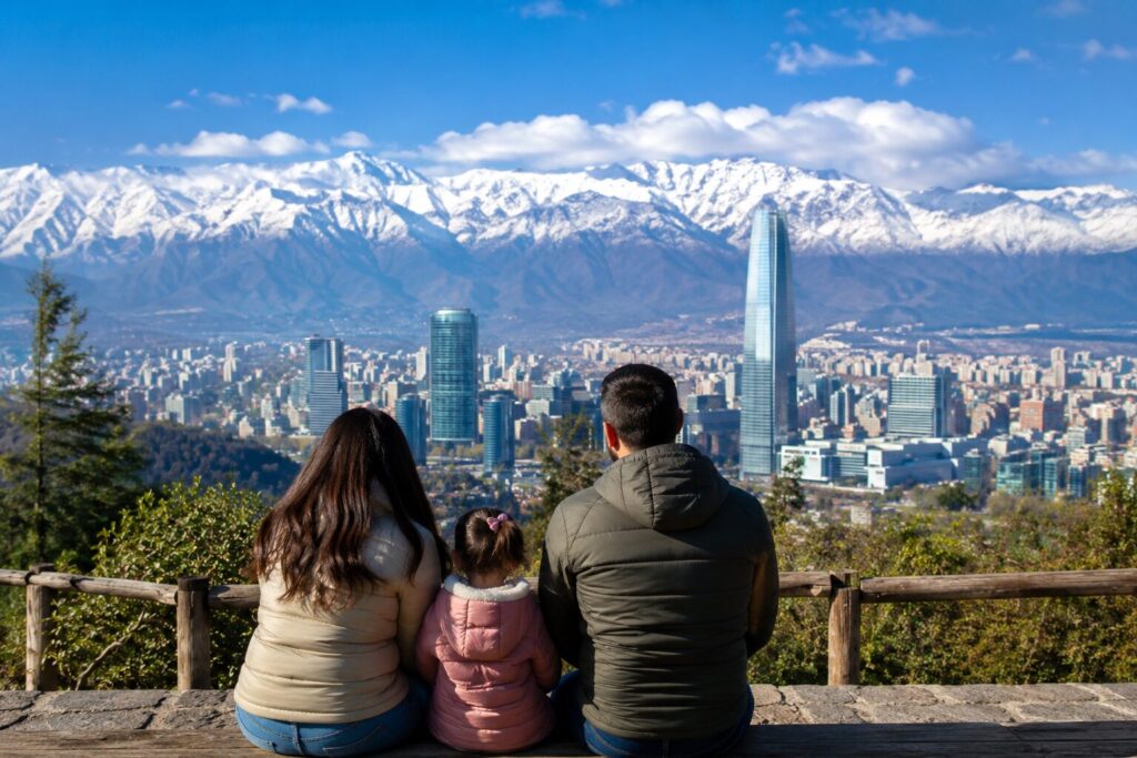 file_00000000104c720eb7346d5beb03aab1 Vista panorâmica de Santiago com a Cordilheira dos Andes ao fundo e uma família observando a paisagem durante viagem ao Chile.